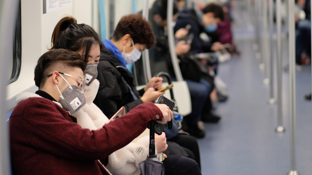 Schutz vor dem Corona-Virus: Menschen mit Atemschutzmasken sitzen in der U-Bahn in Shanghai